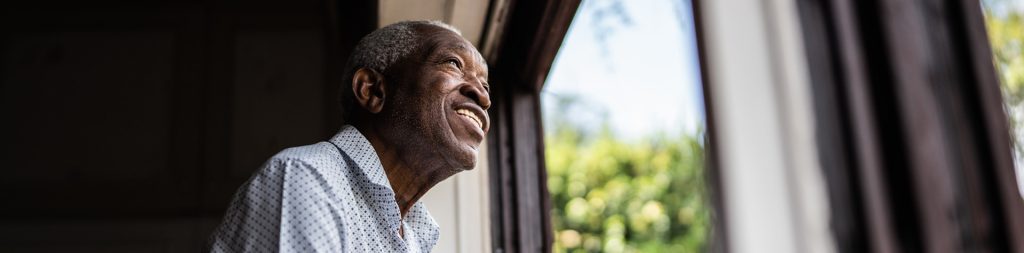 Senior man contemplating looking through the window