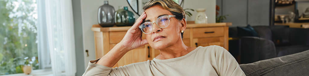 middle age caregiver looking tired sitting on a couch